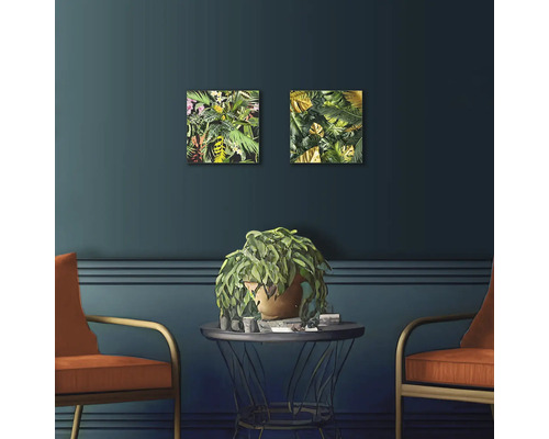 Intérieur décoratif avec deux tableaux de jungle, une table et deux chaises