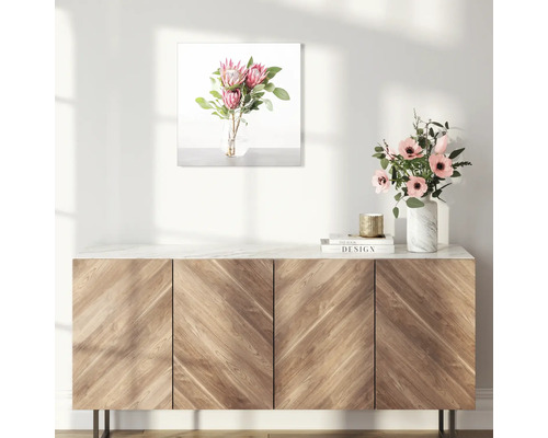 Image décorative avec arrangement floral au-dessus d''un meuble en bois.
