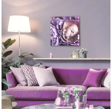 Wohnzimmer mit lila Sofa und Blumenbild an der Wand