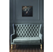 Wohnzimmer mit Sofa und einem Bild von einem Hirsch an der Wand.