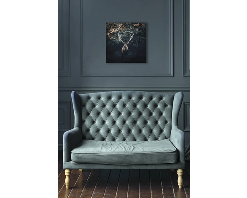 Wohnzimmer mit Sofa und einem Bild von einem Hirsch an der Wand.