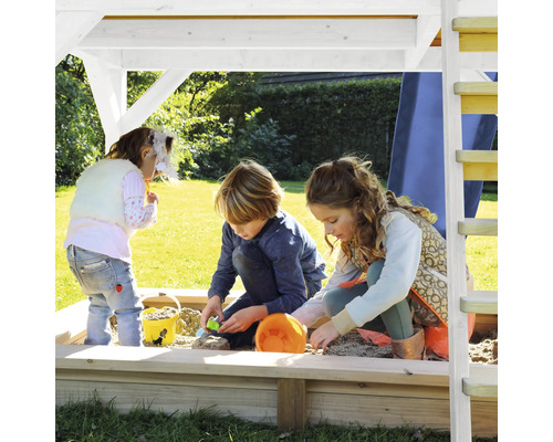 Kinder spielen im Sandkasten unter einem Spielturm