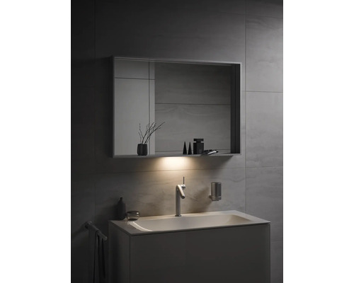 Salle de bains moderne avec lavabo, miroir et éclairage pour une atmosphère lumineuse.