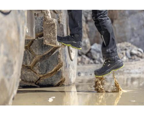 Personne avec chaussures de sécurité montant sur une excavatrice.