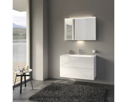 Modernes Badezimmer mit weißem Waschtischunterschrank, Spiegel mit Beleuchtung und grauem Teppich.