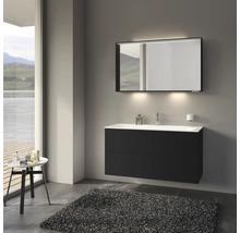 Salle de bains moderne avec meuble sous-lavabo noir, miroir avec éclairage et tapis gris.