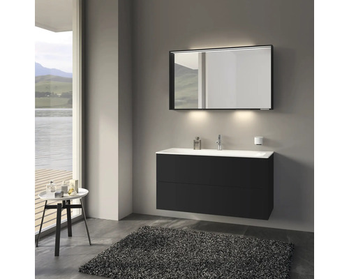 Salle de bains moderne avec meuble sous-lavabo noir, miroir avec éclairage et tapis gris.