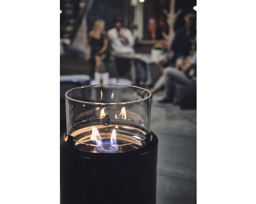 Dekorative Ethanol-Feuerstelle mit Glaszylinder und Personen im Hintergrund