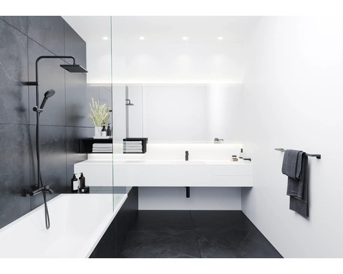 Modernes Badezimmer mit Badewanne, Duscharmatur, Waschtisch und Handtuchhalter.