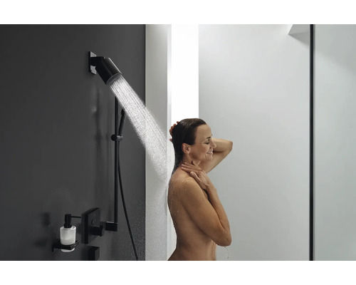 Frau unter einer modernen Duscharmatur mit Seifenspender