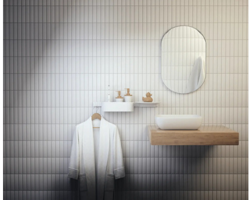 Modernes Badezimmer mit weißen Wandfliesen, Spiegel, Waschtisch und Bademantel