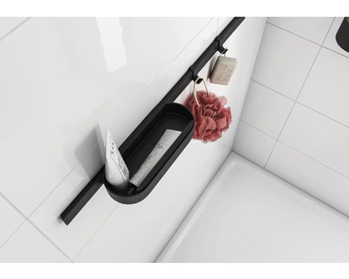 Badezimmer Ablagesystem mit Seife, Badeschwamm und Kosmetikprodukten an einer weißen Wand.