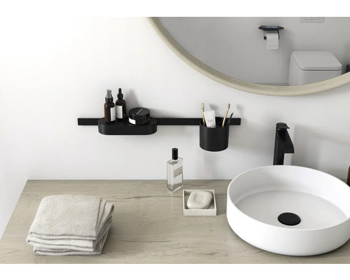 Badezimmer mit Waschbecken, Spiegel und Badaccessoires an der Wand