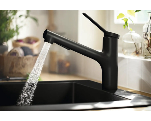 Schwarze Küchenarmatur mit Ausziehbrause und fließendem Wasser in einem Spülbecken
