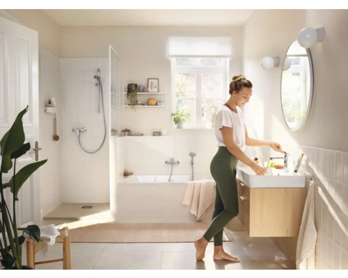 Salle de bain lumineuse avec baignoire, douche, lavabo et miroir
