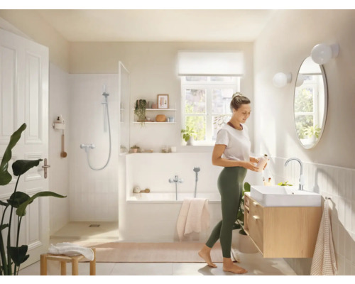 Salle de bains lumineuse avec baignoire, douche, lavabo et miroir au design agréable.