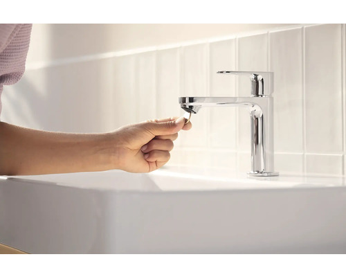 Aufnahme eines Waschtischs mit Einhebelmischer und Person, die einen Stöpsel hält