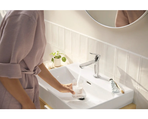 Badezimmerszene mit Waschbecken, Wasserhahn, Person und Badutensilien