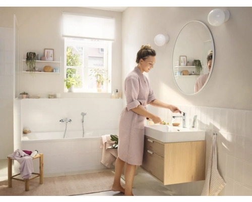 Salle de bains lumineuse avec baignoire, lavabo et miroir