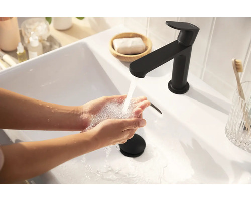 Lavabo avec robinet et mains sous l''eau courante