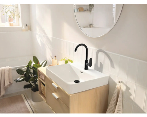 Salle de bain lumineuse avec lavabo, robinet noir et miroir