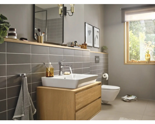 Modernes Badezimmer mit Waschtisch, Spiegel und Toilette.