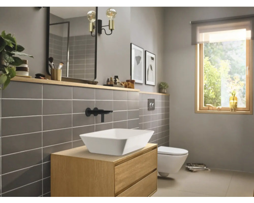 Salle de bains moderne avec meuble-lavabo, vasque, miroir et WC.