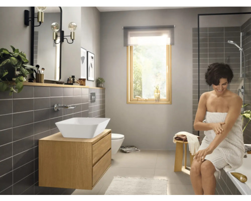 Salle de bain lumineuse avec lavabo sur meuble sous-lavabo, miroir et douche