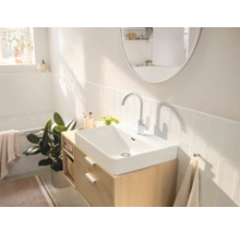 Salle de bains lumineuse avec lavabo, robinet, miroir et meuble sous-lavabo en bois
