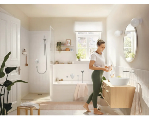 Helles Badezimmer mit Dusche, Badewanne, Waschtisch und einer Frau