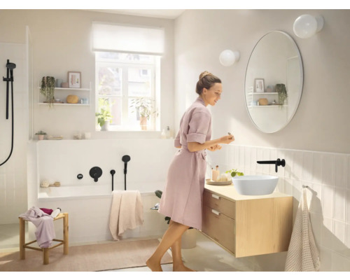 Helles Badezimmer mit Badewanne, Waschtisch mit Aufsatzwaschbecken und ovalem Spiegel