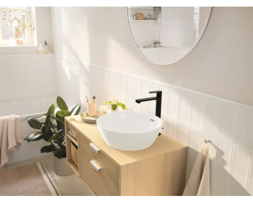 Salle de bains lumineuse avec lavabo à poser, meuble sous-lavabo et robinet