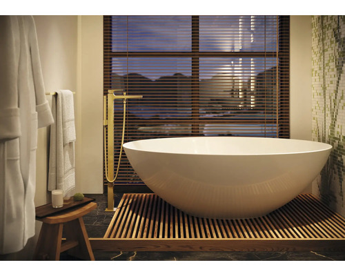 Freistehende Badewanne im Badezimmer mit Armatur, Hocker und Handtüchern