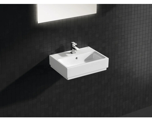 Lavabo en céramique avec robinet et miroir rectangulaire dans la salle de bain.