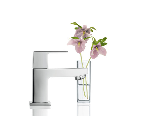 Robinet moderne en métal à côté de fleurs dans un vase pour la salle de bain