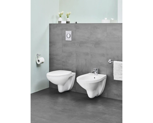 Modernes Badezimmer mit wandhängendem WC und Bidet in Weiß, ergänzt durch WC-Papierhalter und Handtuchhalter