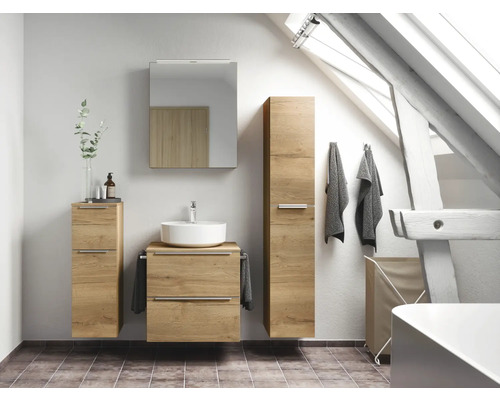 Salle de bains avec lavabo, armoire de toilette et armoire haute en aspect bois devant une fenêtre de toit
