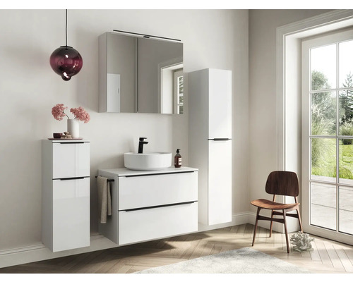 Salle de bains moderne avec lavabo, armoire de toilette et armoires hautes dans une pièce lumineuse
