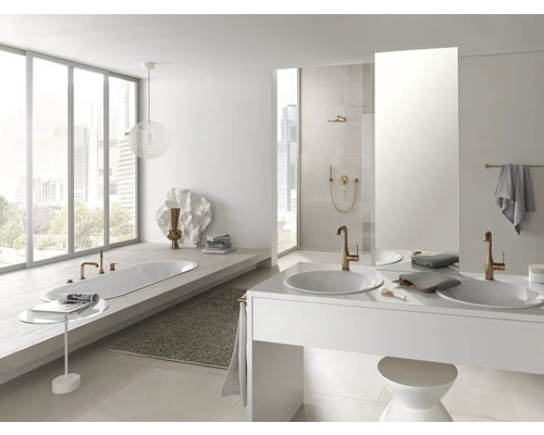 Salle de bains lumineuse avec baignoire, lavabos et robinets