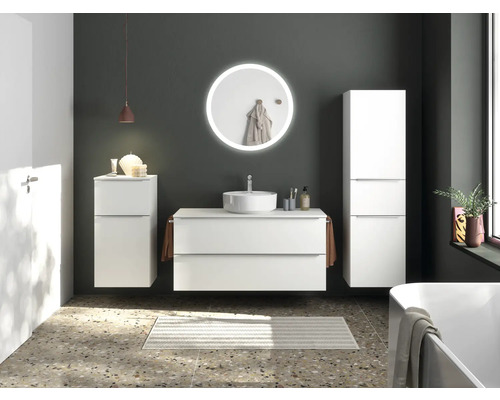 Helles Badezimmer mit Waschtisch, Spiegel, Schrank und Badewanne für eine ordentliche und moderne Atmosphäre.