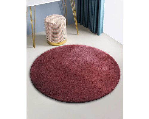 Tapis rond en fausse fourrure dans une pièce avec tabouret et table