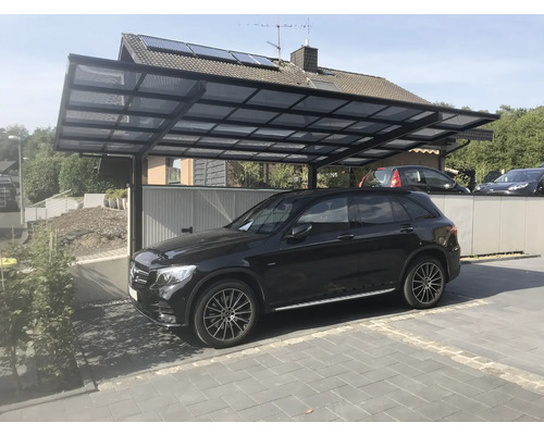 Un abri de voiture en métal avec une voiture noire en dessous