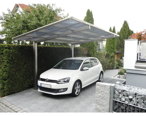 Voiture sous un abri de voiture dans un parking pavé