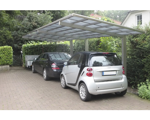 Abri de voiture avec deux voitures garées et une remorque