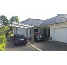Carport aus Metall mit zwei Autos vor einem Wohnhaus