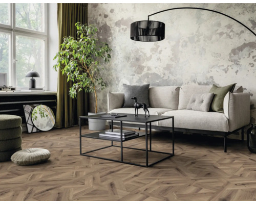 Wohnzimmer mit Sofa, Couchtisch, Zimmerpflanze und Holzfußboden in Fischgrätmuster