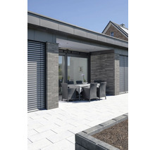 Terrasse mit Gartenmöbeln, Steinboden und modernem Haus im Hintergrund