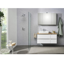 Helles Badezimmer mit Waschbeckenunterschrank, Spiegelschrank, Dusche und Badematte.