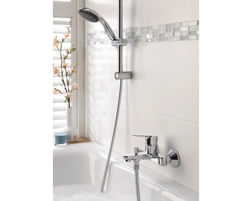Salle de bains avec robinetterie de baignoire, barre de douche et douchette
