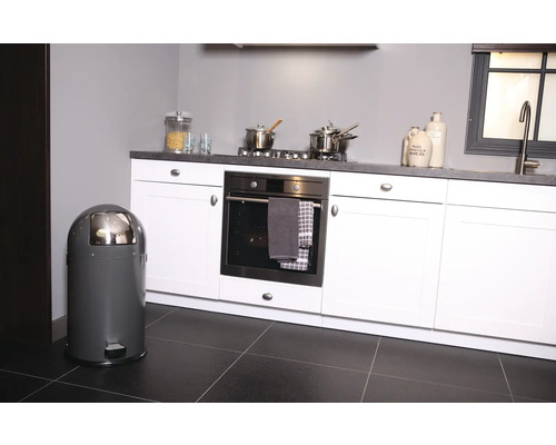 Poubelle à pédale grise dans une cuisine moderne avec armoires et appareils blancs